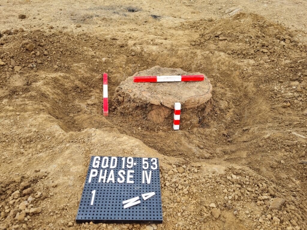 Urn excavated with photo board and three scales